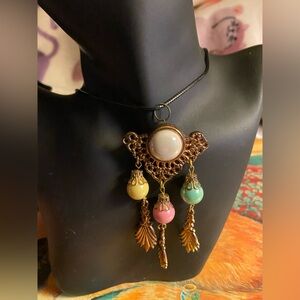 Vintage iridescent charm with necklace 8 inches long black cord necklace.